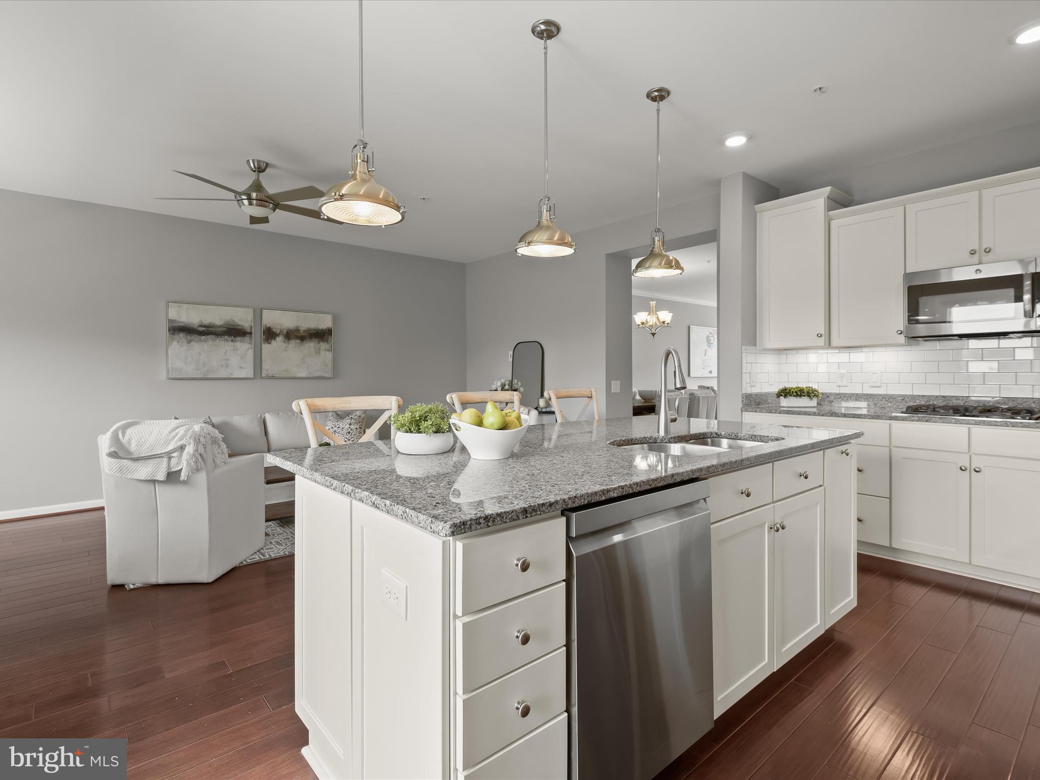 179 Copley Circle, Unit 30B Gaithersburg, MD 20878 - Photo 19 of 41 a kitchen with a sink dishwasher a stove a dining table with chairs and wooden floor