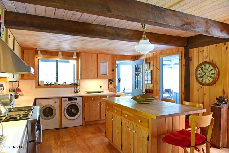 57 Hayes Pond Road Otis, MA 01253 - Photo 18 of 36 a kitchen with a stove a microwave oven cabinets and a dining table
