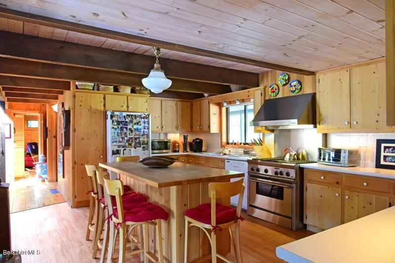 57 Hayes Pond Road Otis, MA 01253 - Photo 19 of 36 a kitchen with stainless steel appliances granite countertop a stove a sink dishwasher and cabinets with wooden floor