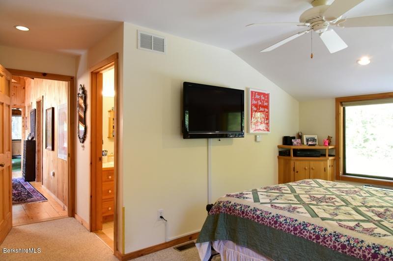 57 Hayes Pond Road Otis, MA 01253 - Photo 23 of 36 a bedroom with a bed and a flat screen tv