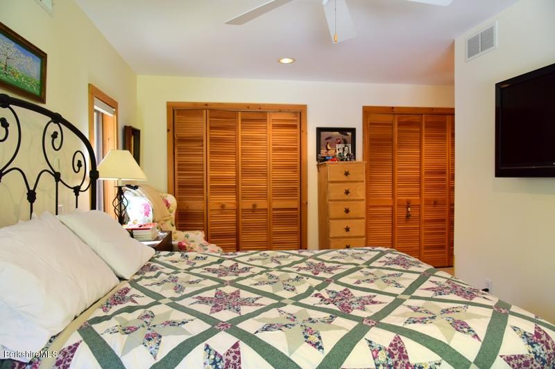 57 Hayes Pond Road Otis, MA 01253 - Photo 24 of 36 a bedroom with a bed and a flat screen tv