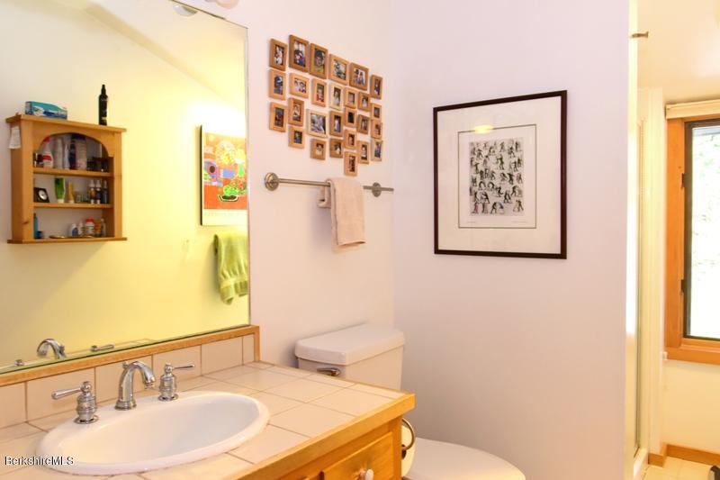 57 Hayes Pond Road Otis, MA 01253 - Photo 25 of 36 a bathroom with a sink mirror vanity and toilet