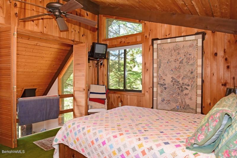 57 Hayes Pond Road Otis, MA 01253 - Photo 27 of 36 a bedroom with a bed a table and chair