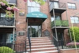 a front view of a house with a tree in front