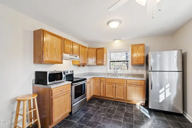 a kitchen with stainless steel appliances granite countertop a refrigerator sink and microwave