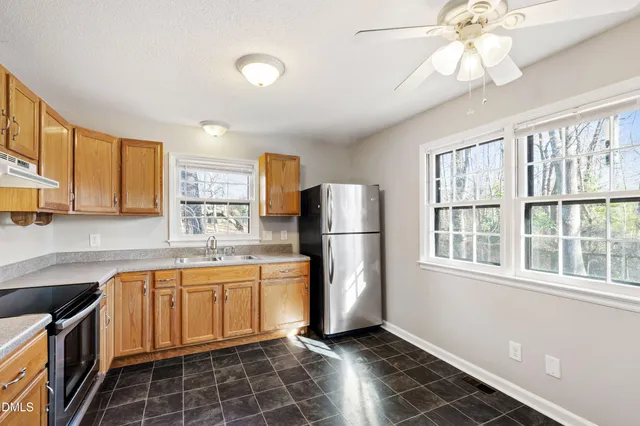 a kitchen with a sink a refrigerator and cabinets