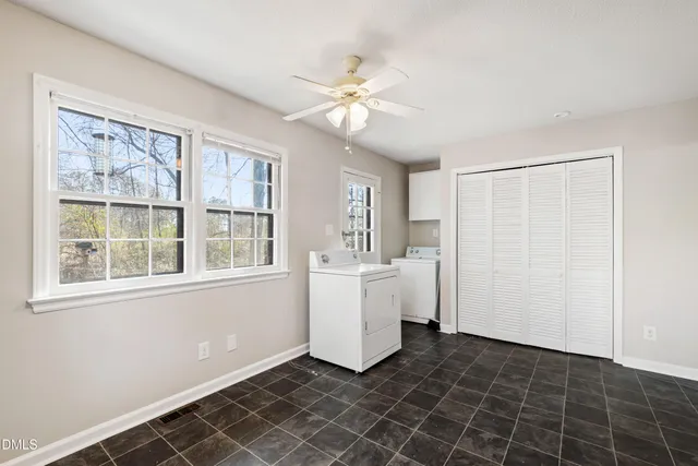 an empty room with a window and a ceiling fan