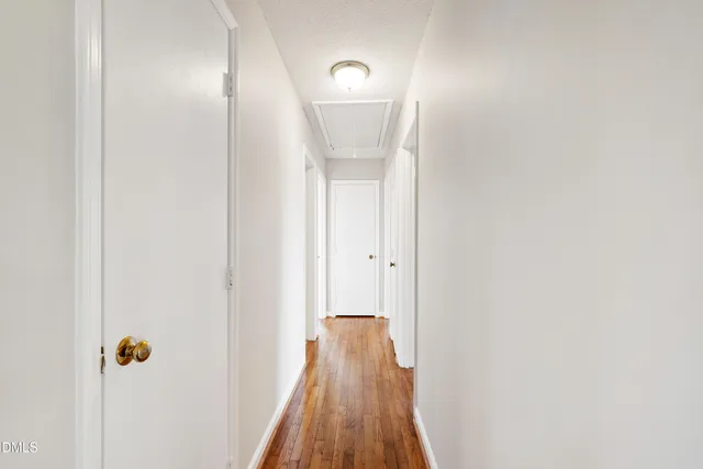 a view of a hallway with wooden floor and closet