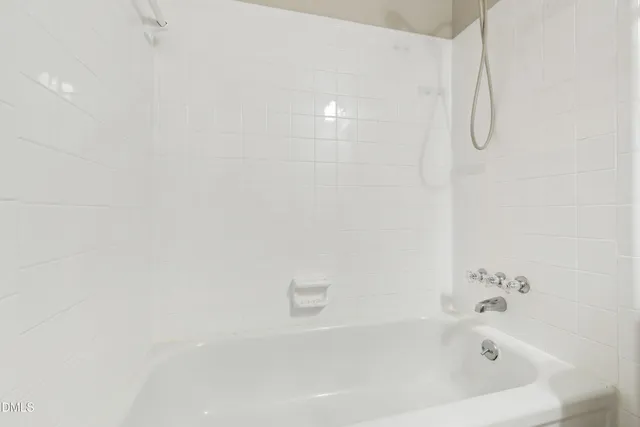 a white bath tub sitting next to a white sink and vanity