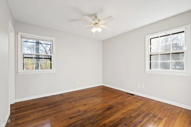 a view of a room with wooden floor and windows