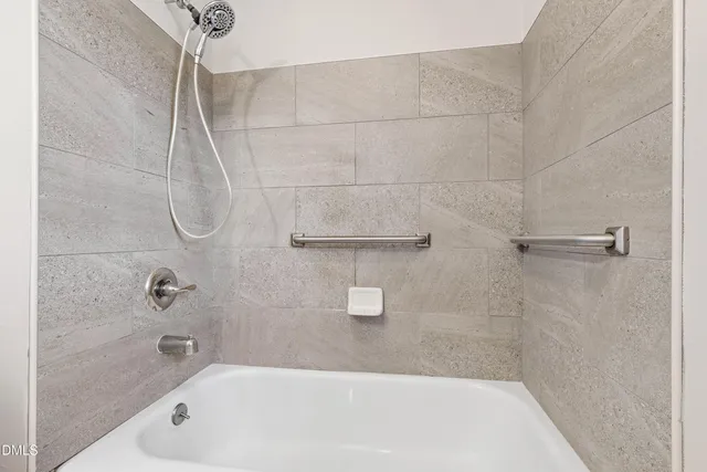 a bathroom with a bath tub with a shower