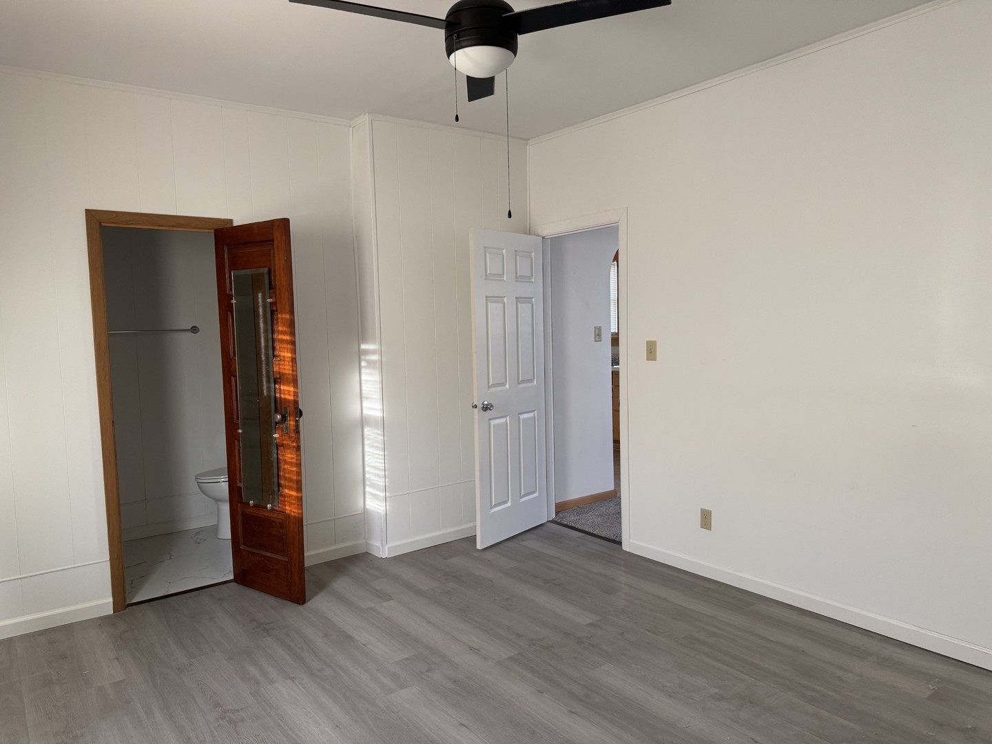 102 West 3rd Street Oglesby, IL 61348 - Photo 8 of 12 a view of an empty room with wooden floor and a ceiling fan