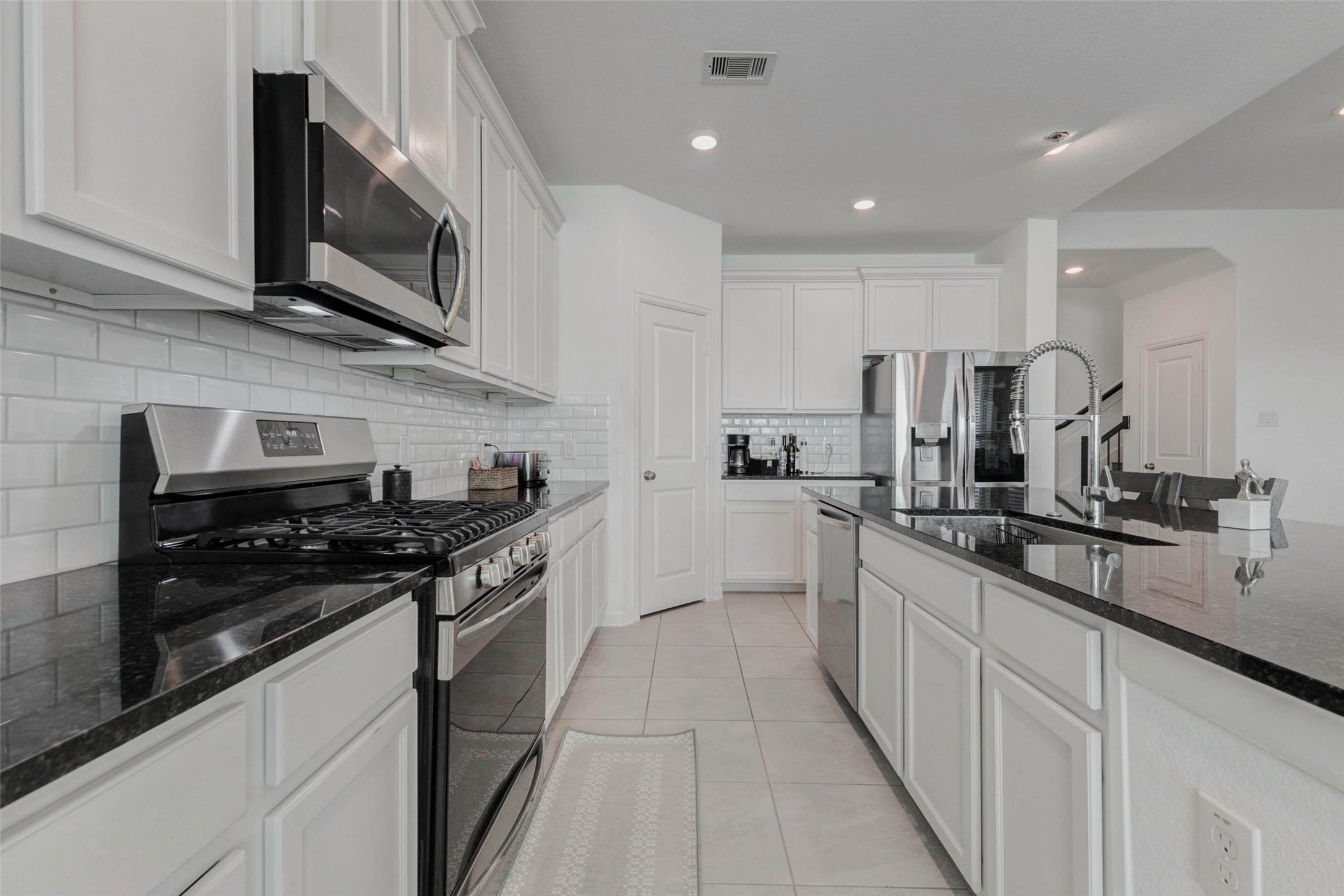 3711 Castle Rock Drive Rosenberg, TX 77469 - Photo 14 of 46 a kitchen with stainless steel appliances granite countertop grey cabinets a stove a sink and dishwasher