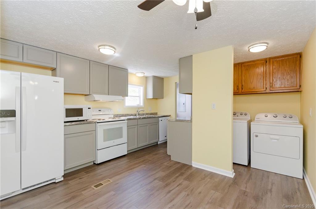 71 Jones Road Leicester, NC 28748 - Photo 11 of 20 a kitchen with a refrigerator a stove top oven a sink and cabinets