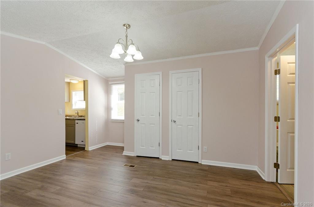71 Jones Road Leicester, NC 28748 - Photo 14 of 20 an empty room with wooden floor chandelier and windows