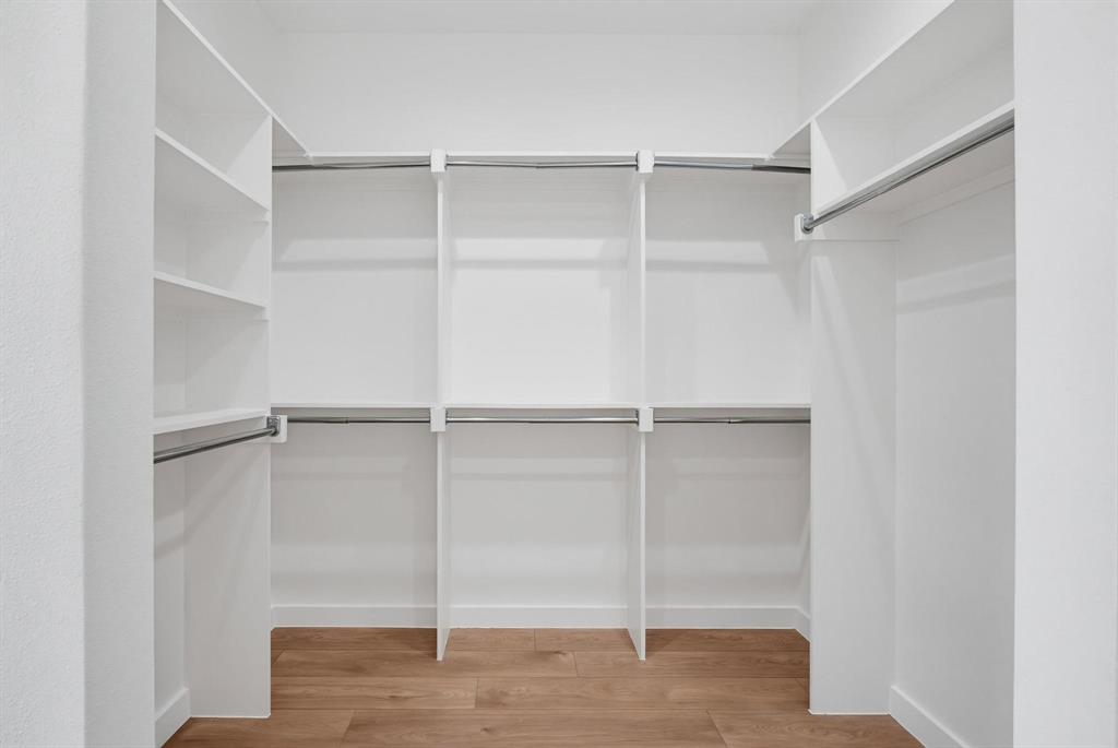 508 South O Connor Road Irving, TX 75060 - Photo 17 of 21 Walk-in closet featuring built-in shelving, multiple hanging rods, and wood-finish flooring