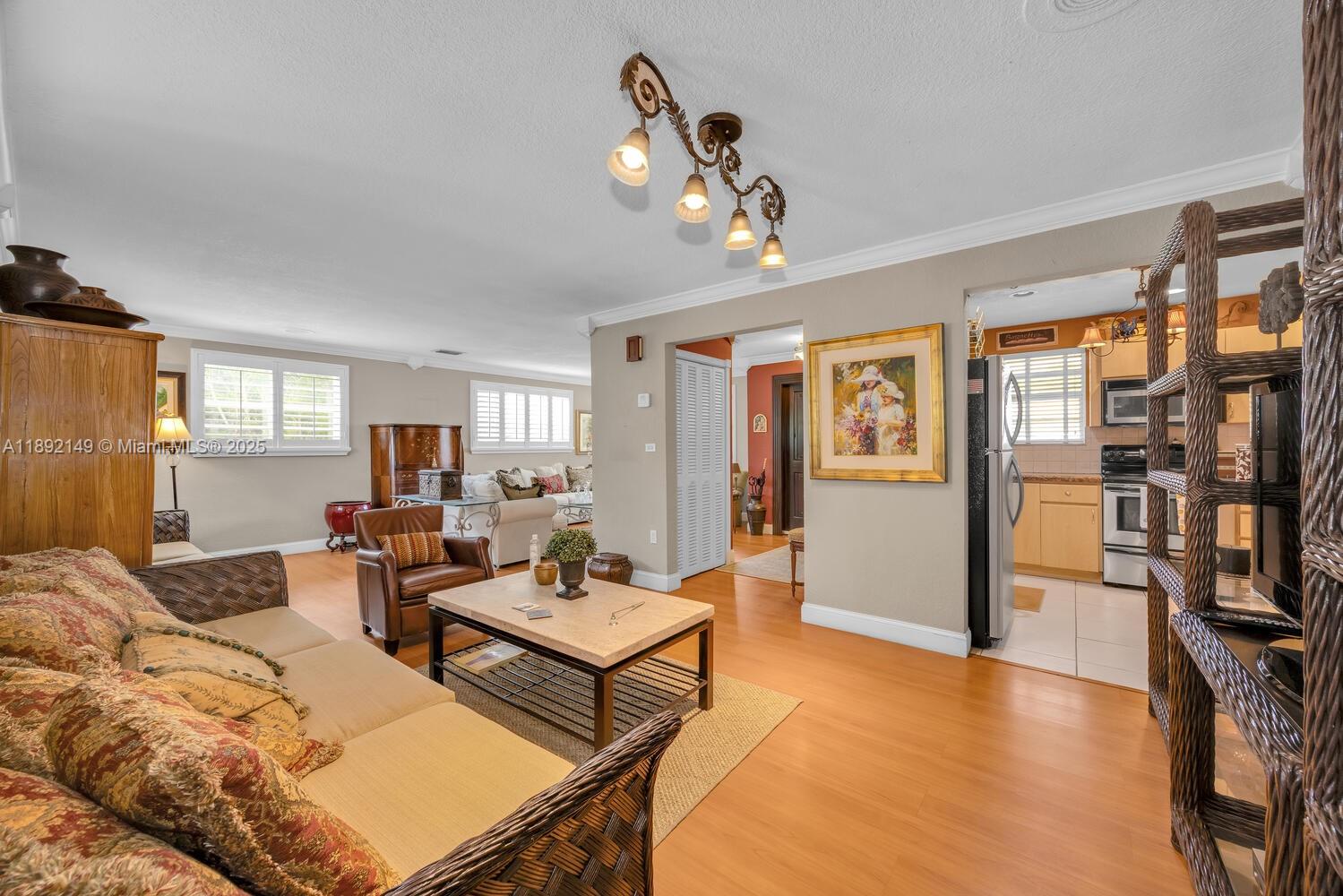 825 El Rado Street Coral Gables, FL 33134 - Photo 13 of 40 a living room with furniture a bookshelf and kitchen view