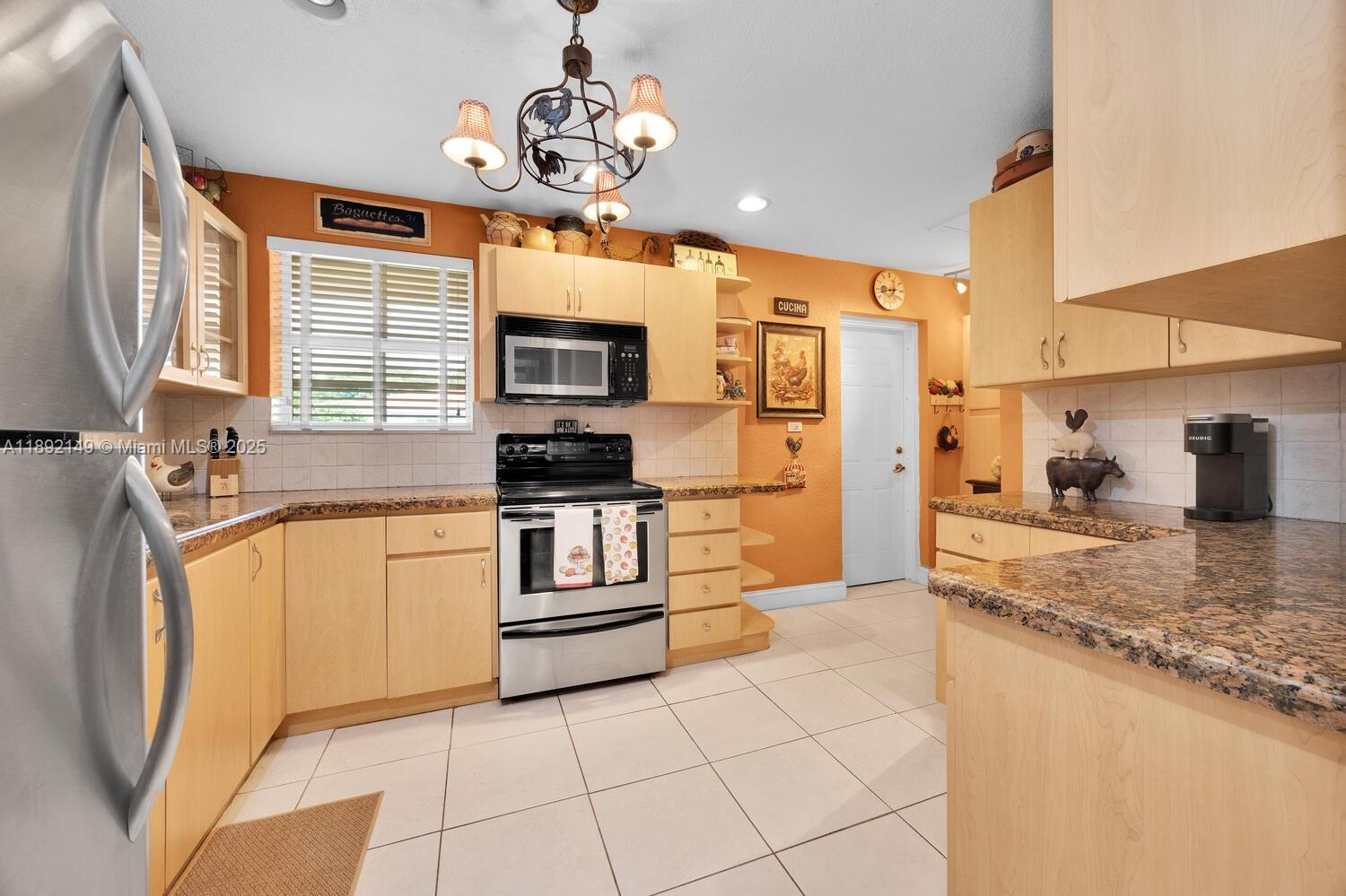 825 El Rado Street Coral Gables, FL 33134 - Photo 14 of 40 a kitchen with stainless steel appliances granite countertop a sink refrigerator stove and microwave