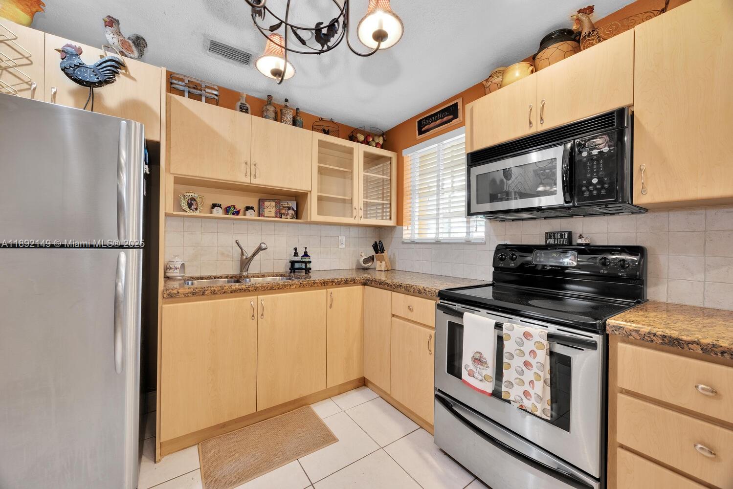 825 El Rado Street Coral Gables, FL 33134 - Photo 16 of 40 a kitchen with stainless steel appliances granite countertop a refrigerator a stove a sink and a microwave