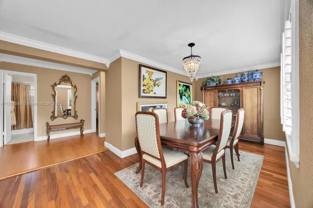 a dining room with furniture a chandelier and wooden floor