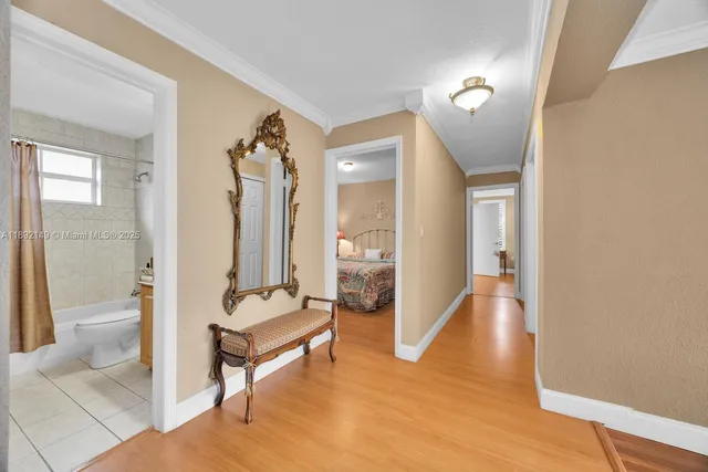 a view of a hallway with wooden floor and a living room