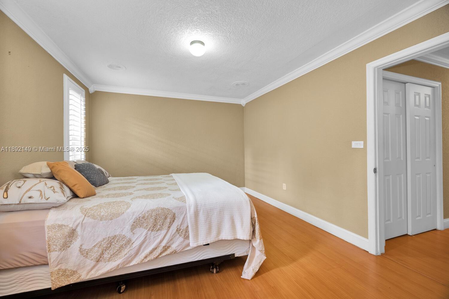 825 El Rado Street Coral Gables, FL 33134 - Photo 25 of 40 a bedroom with a bed and wooden floor