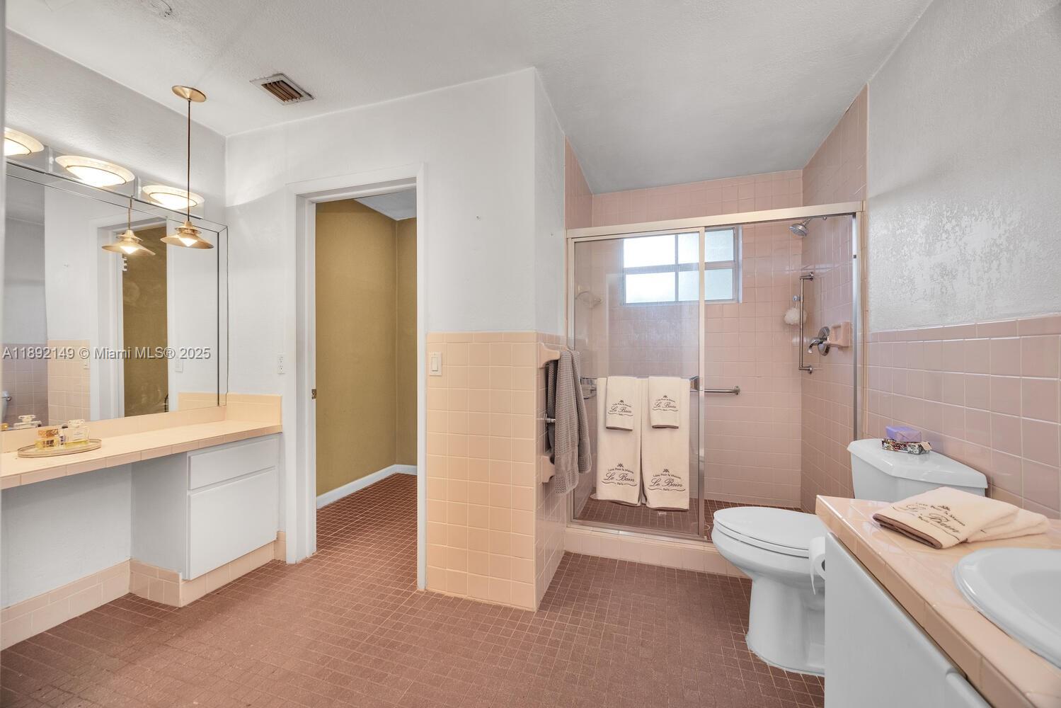 825 El Rado Street Coral Gables, FL 33134 - Photo 27 of 40 a bathroom with a granite countertop sink a toilet a mirror and shower