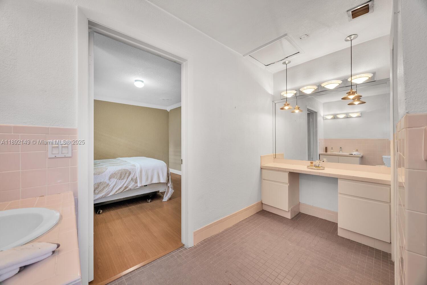 825 El Rado Street Coral Gables, FL 33134 - Photo 29 of 40 a en suite bathroom with a double vanity sink a toilet a shower and a mirror