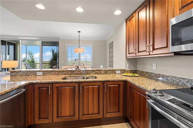 a kitchen with granite countertop wooden cabinets and a stove top oven