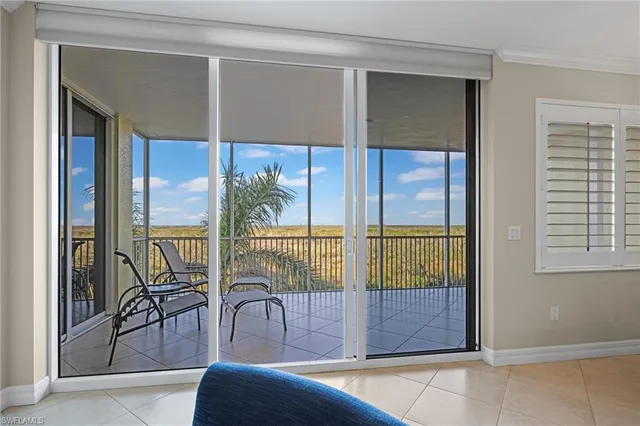a dining room with glass top table and chairs