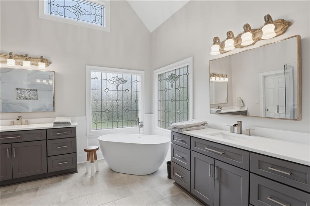 2950 Callie Still Road Lawrenceville, GA 30045 - Photo 26 of 77 a bathroom with a tub double sink mirror and window