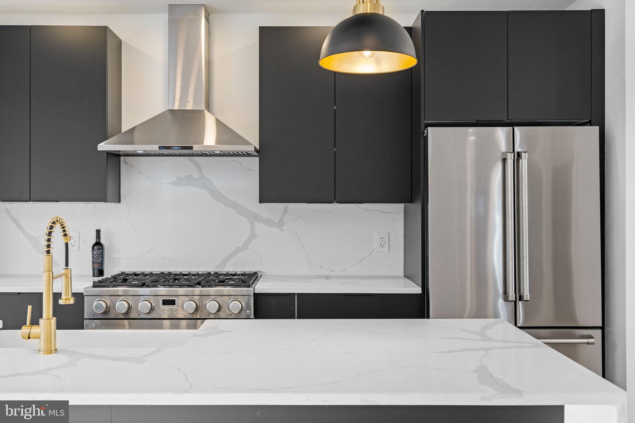 222 Church Road Ardmore, PA 19003 - Photo 17 of 69 a kitchen with stainless steel appliances granite countertop a refrigerator a stove and a sink with wooden cabinets