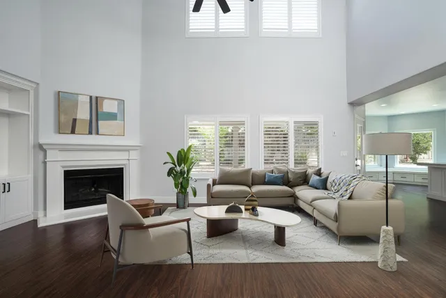 a living room with furniture large window and fireplace