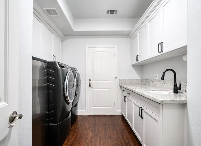 a utility room with sink dryer and washer