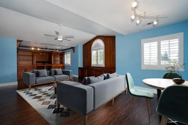 a living room with furniture flat screen tv and a large window
