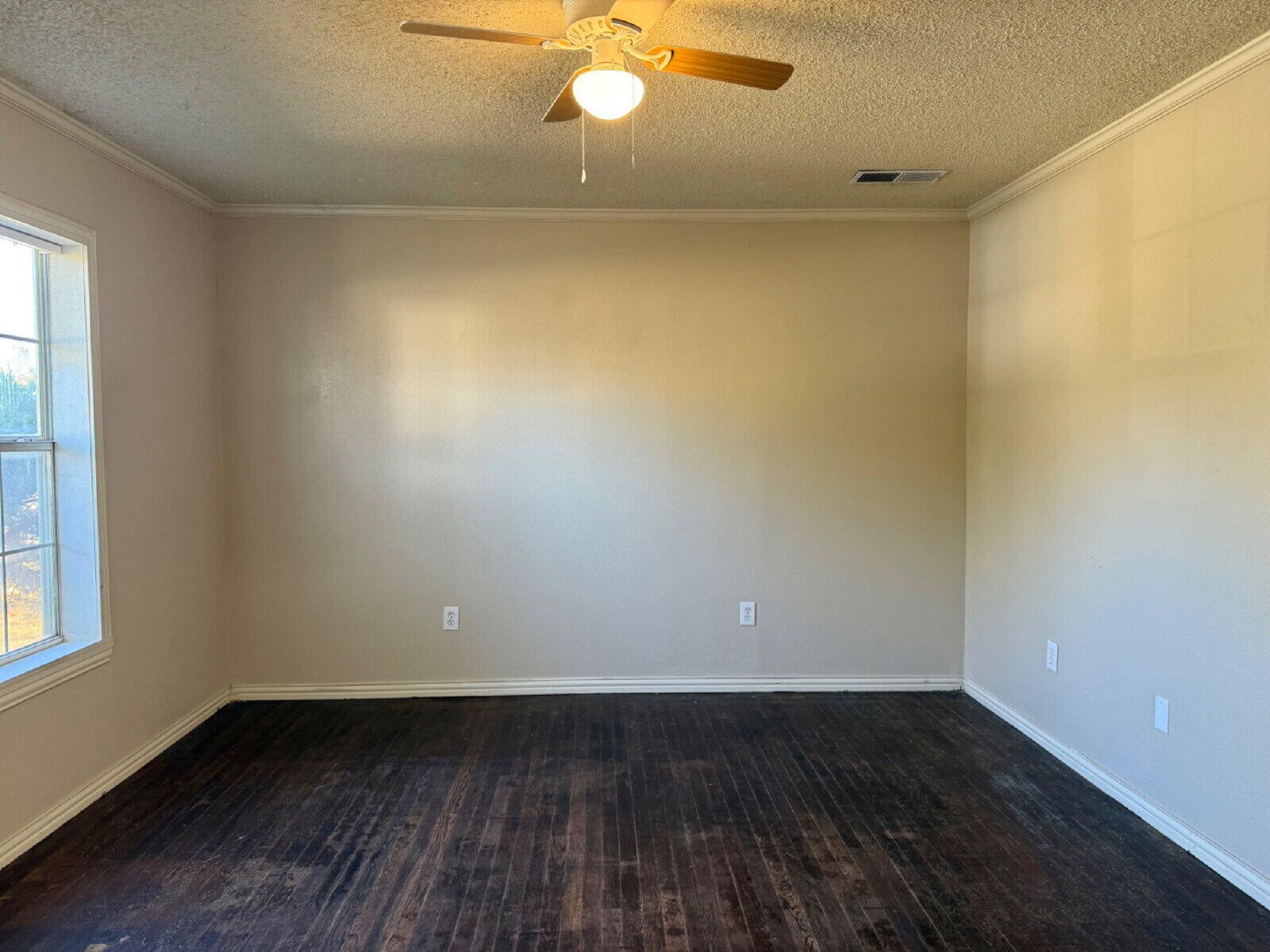 2423 25th Street Lubbock, TX 79411 - Photo 3 of 14 a view of an empty room with wooden floor and a window