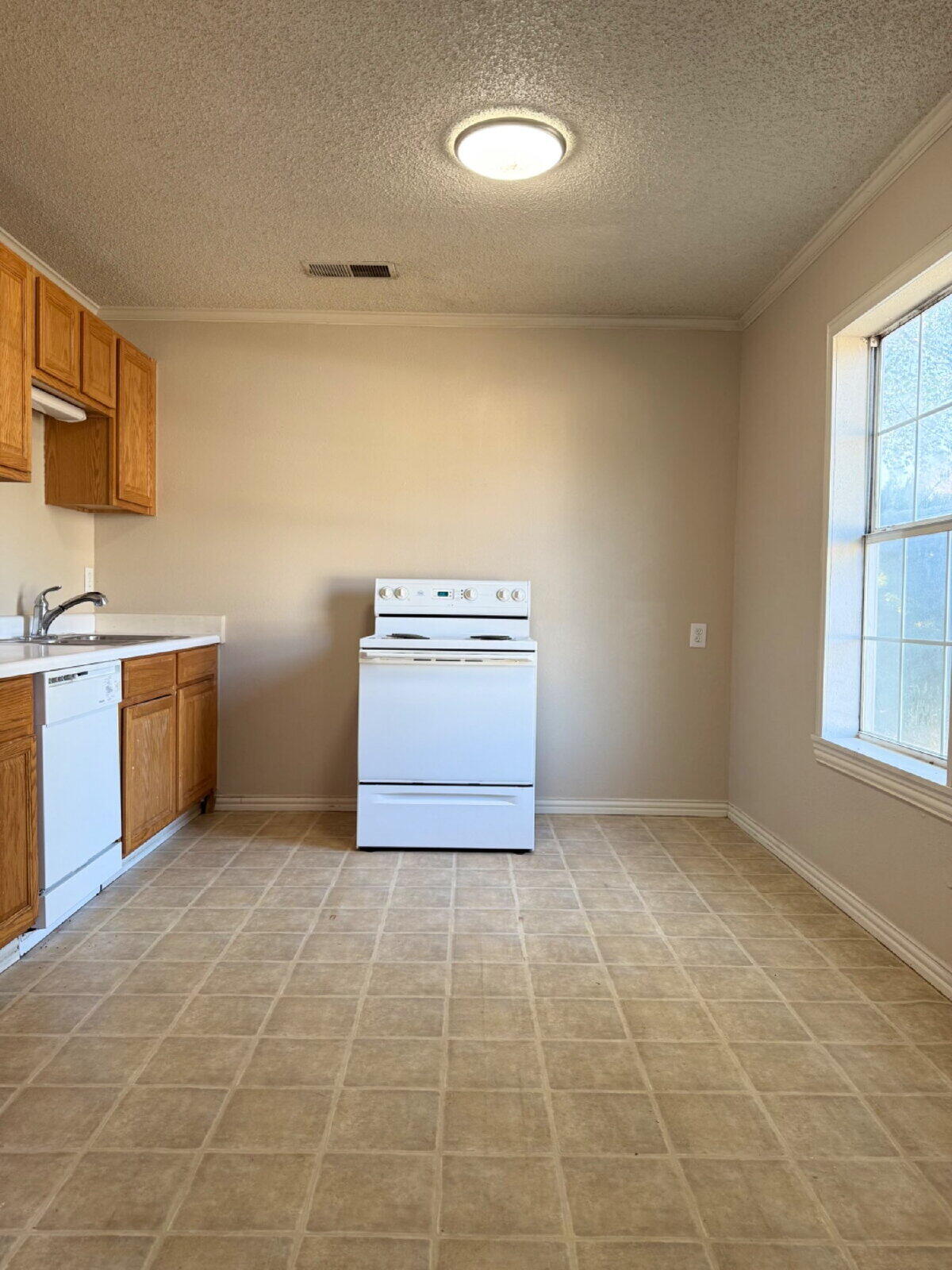 2423 25th Street Lubbock, TX 79411 - Photo 6 of 14 a kitchen with a stove a sink and a window