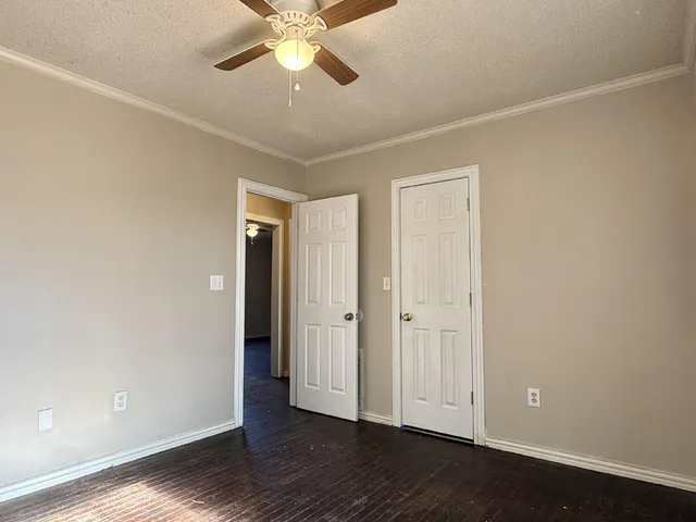 an empty room with wooden floor and door