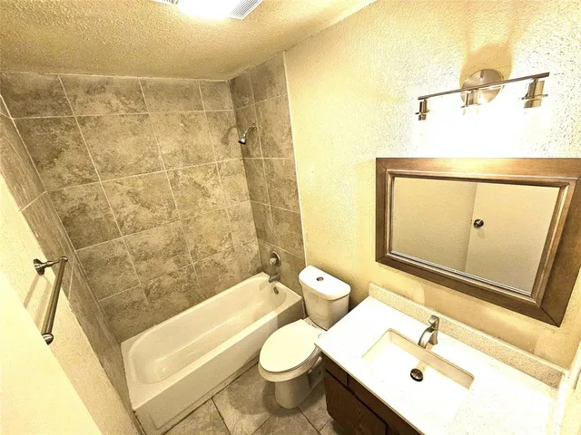 a bathroom with a toilet sink mirror and shower