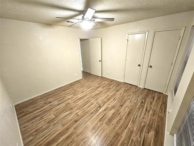 a view of a big room with wooden floor and fan