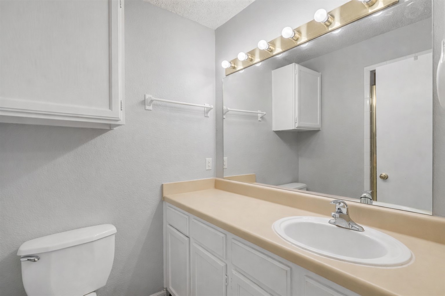 3115 Helms Street, Unit 210 Austin, TX 78705 - Photo 6 of 17 a bathroom with a sink a toilet and a mirror