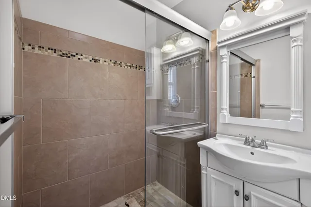 a bathroom with a sink mirror and a shower
