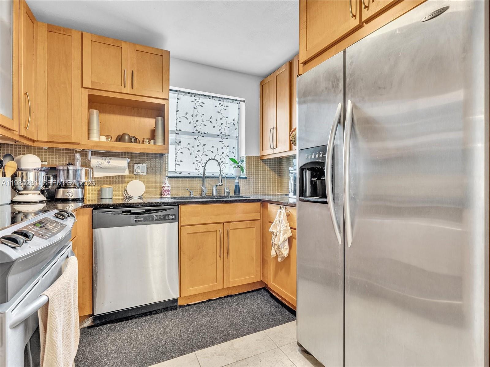 1236 Alton Road, Unit 304 Miami Beach, FL 33139 - Photo 12 of 28 a kitchen with stainless steel appliances granite countertop a refrigerator a stove and a sink with large window