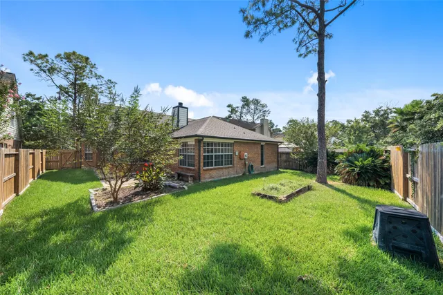 a view of a house with backyard and a tree