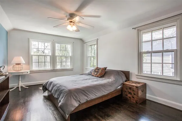 a spacious bedroom with a bed and a table chair in it