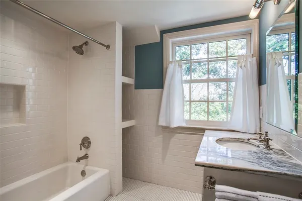 a bathroom with a granite countertop tub and a sink