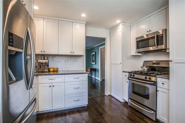 a kitchen with stainless steel appliances granite countertop a stove a refrigerator and a microwave