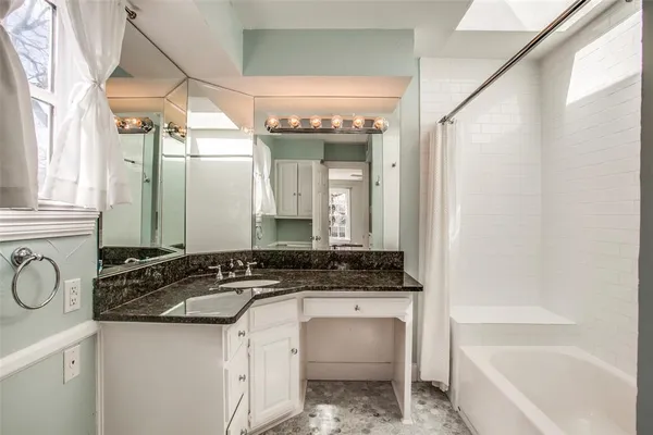 a bathroom with a sink a bathtub and a window