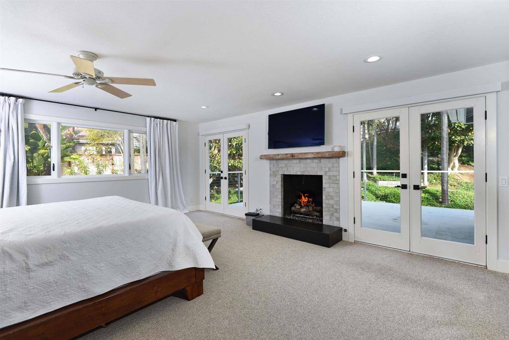 1739 Sienna Canyon Drive Encinitas, CA 92024 - Photo 17 of 29 a spacious bedroom with a balcony a bed and a fireplace
