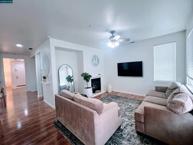 a living room with furniture a flat screen tv and a fireplace